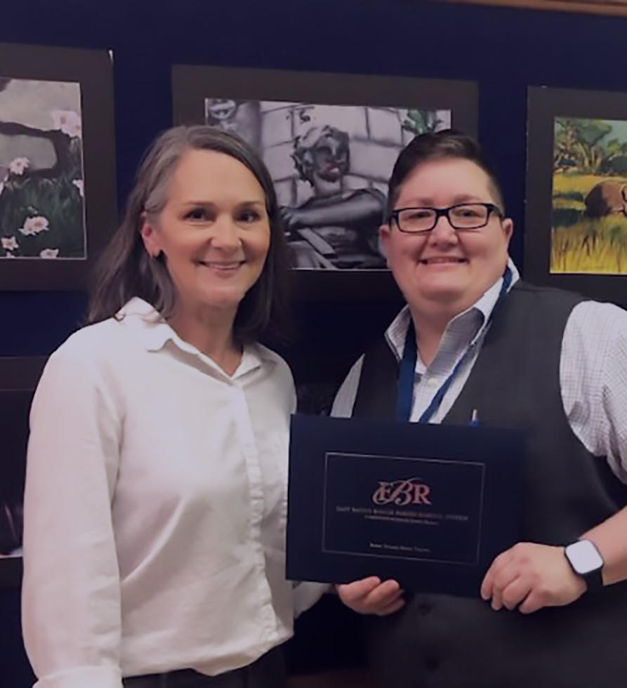 Graduate proudly holding diploma